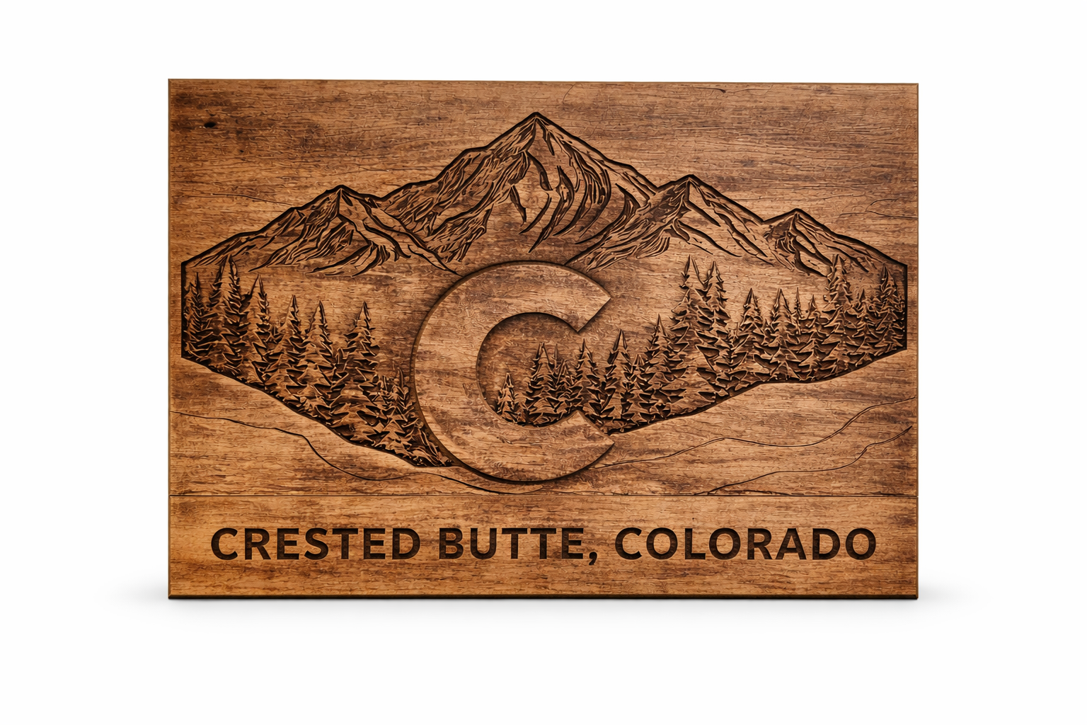 Wooden sign with engraved mountain scenery, trees, and the text 'CRESTED BUTTE, COLORADO'.