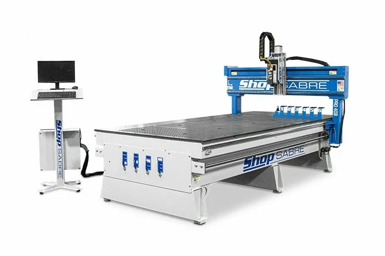 Large industrial CNC machine with a computer station for operation, used for precision cutting or engraving.