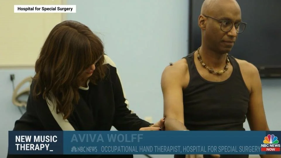 A segment on NBC News featuring an occupational hand therapist from Hospital for Special Surgery, providing therapy to a musician. The man is wearing glasses and a black sleeveless shirt, with a necklace.
