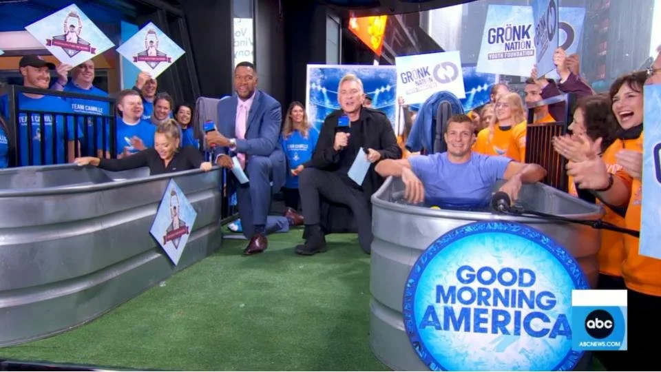 A segment on Good Morning America featuring Rob Gronkowski and Camille Kostek competing live in an ice bath challenge to raise money for charity.