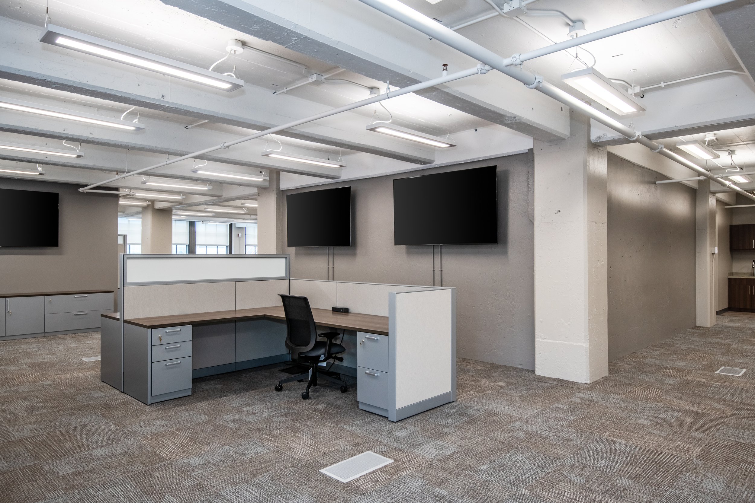 Interior office space at the Dayton Motor Car Building showcasing open layouts, exposed concrete ceilings, and original multi-pane windows in a historic downtown Dayton commercial building.