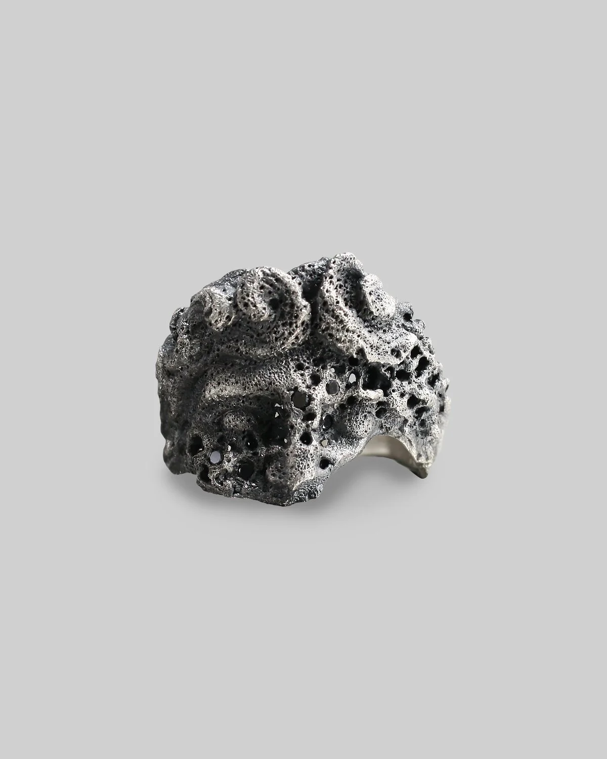 Anello Ell Milano IDOL, in argento, con texture porosa scolpita allover , impreziosito da diamantini neri incastonati.