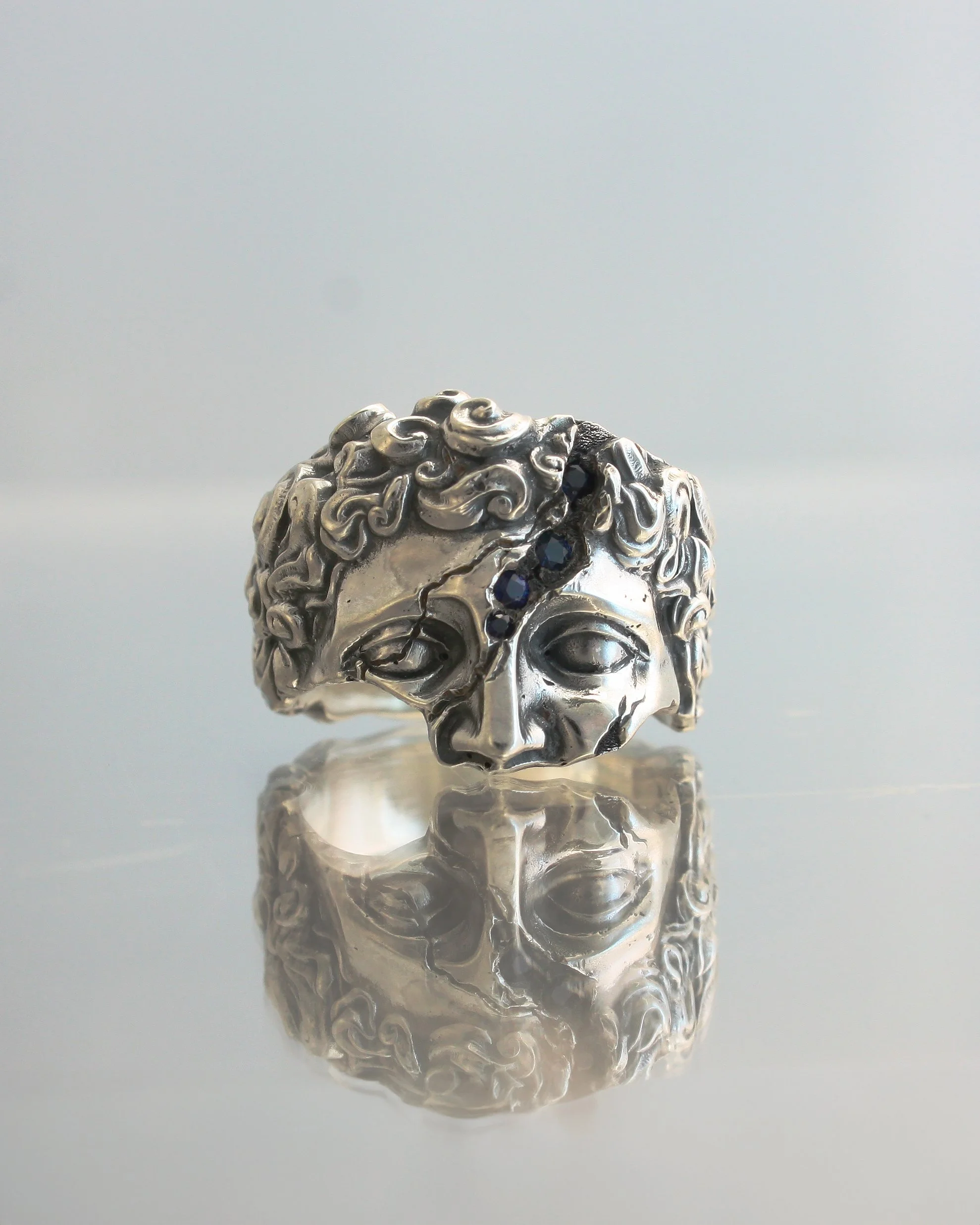 Anello IDOL in argento con frattura incisa e zaffiri blu incastonati all'interno.