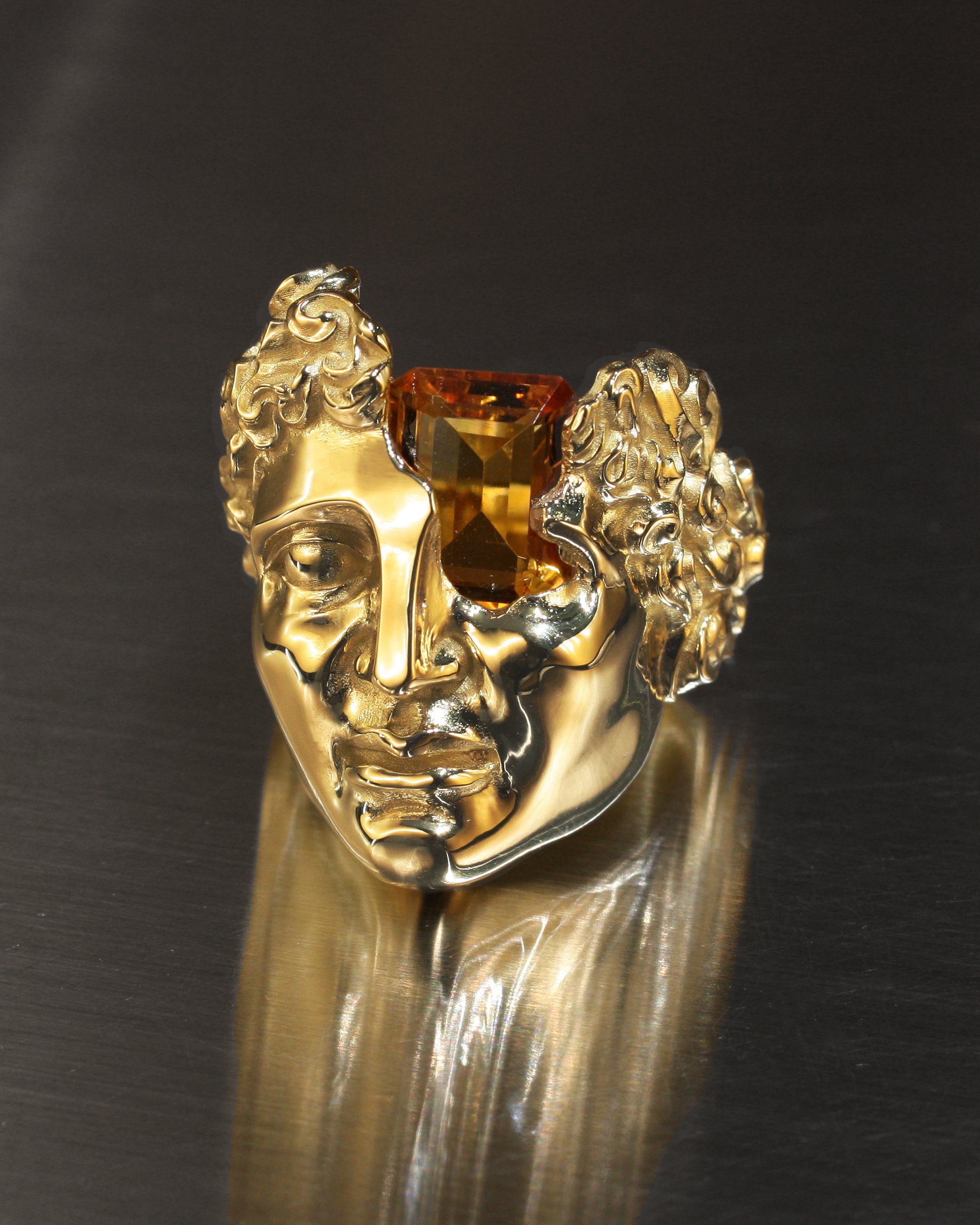 Anello IDOL in oro 18kt con volto scolpito di ispirazione classicista e pietra quarzo citrino incastonata in sospensione. finitura oro lucido.