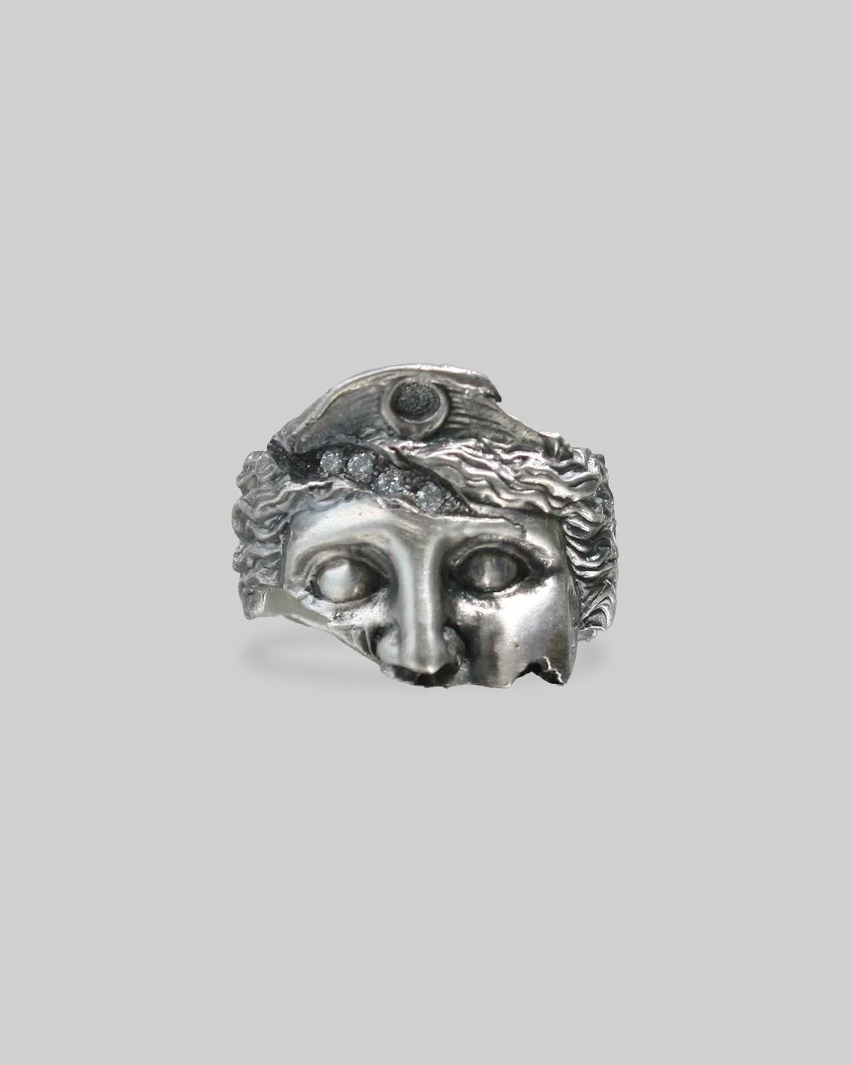 Anello d'argento IDOL con maschera di stile antico con dettagli di un volto Artemide e frattura incisa con diamanti incastonati all'interno.
