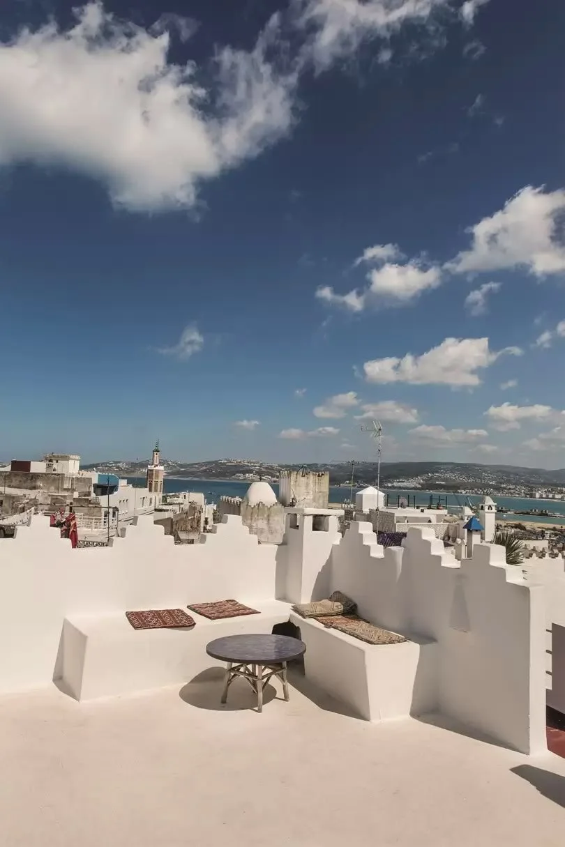 White rooftop terrace overlooking Tangier, Morocco featured in a Mediterranean travel and design guide.