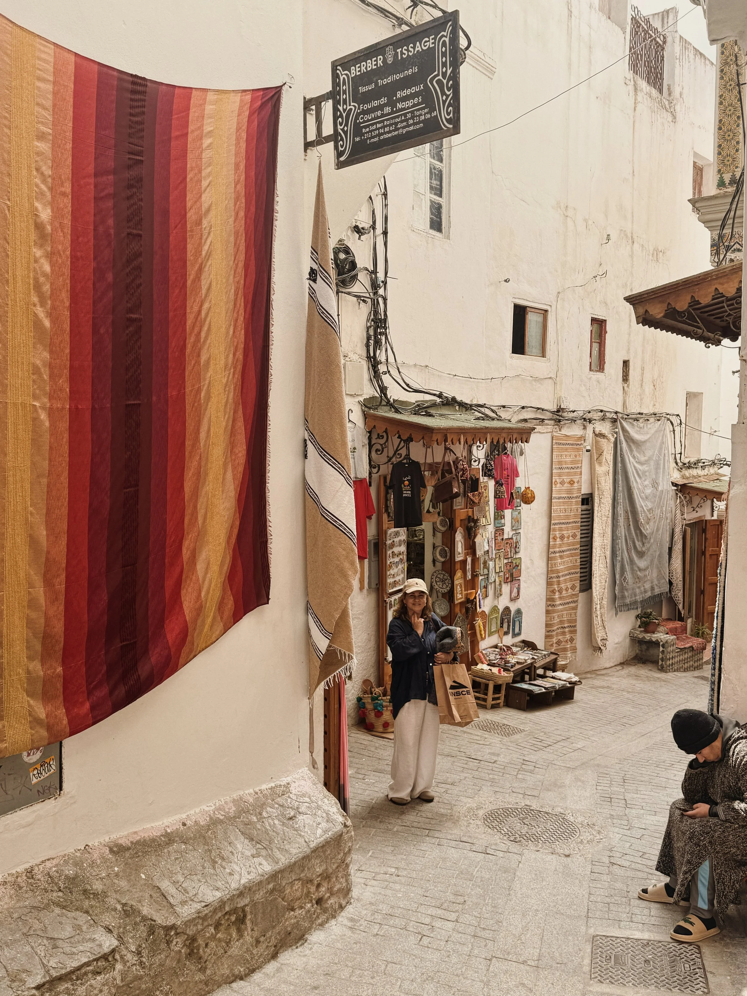 Textile-lined street in Tangier, Morocco, with traditional shops, layered textures and warm North African atmosphere.