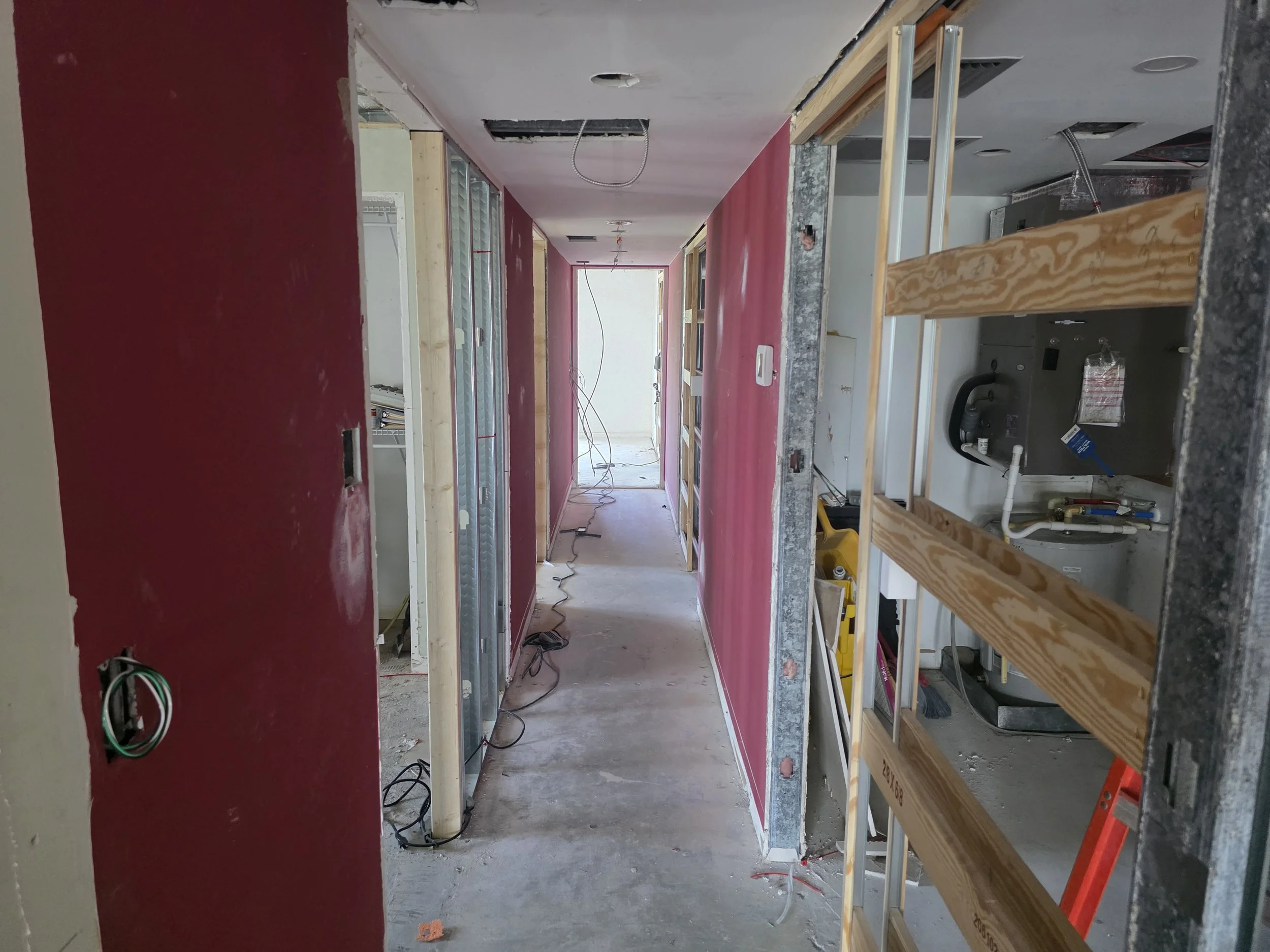 J&LD: View down hallway, all floor tile removed.  Pocket door framing being installed for laundry. All other doors receive swing doors except 2 bathrooms that receive pocket doors.