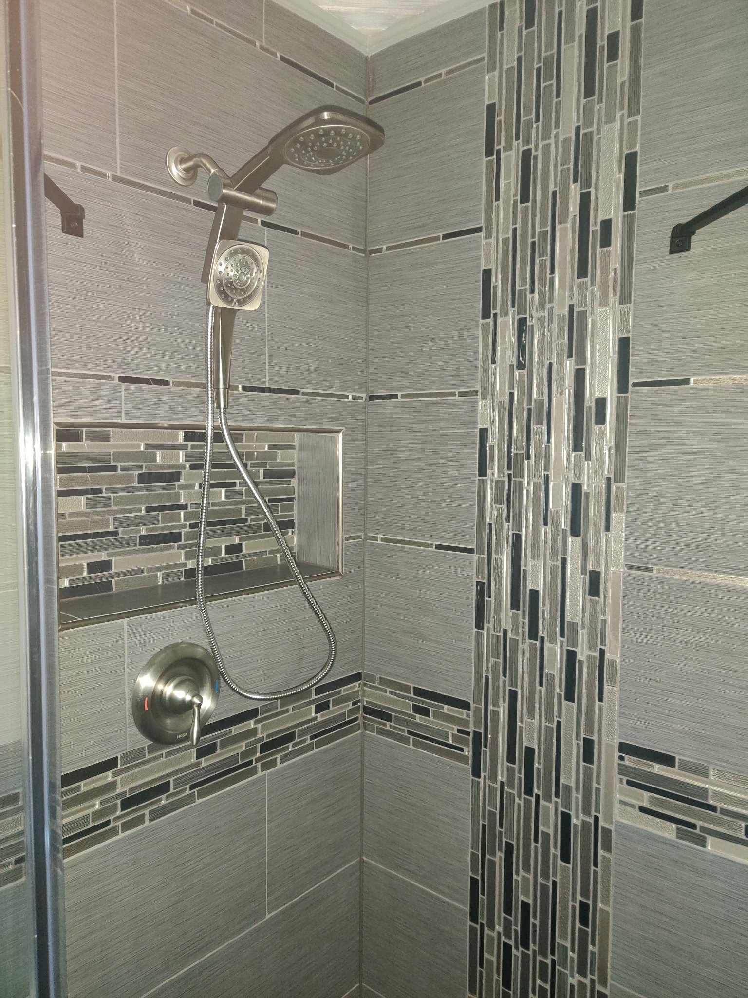 Ceramic, large format tiles with glass waterfall pattern.