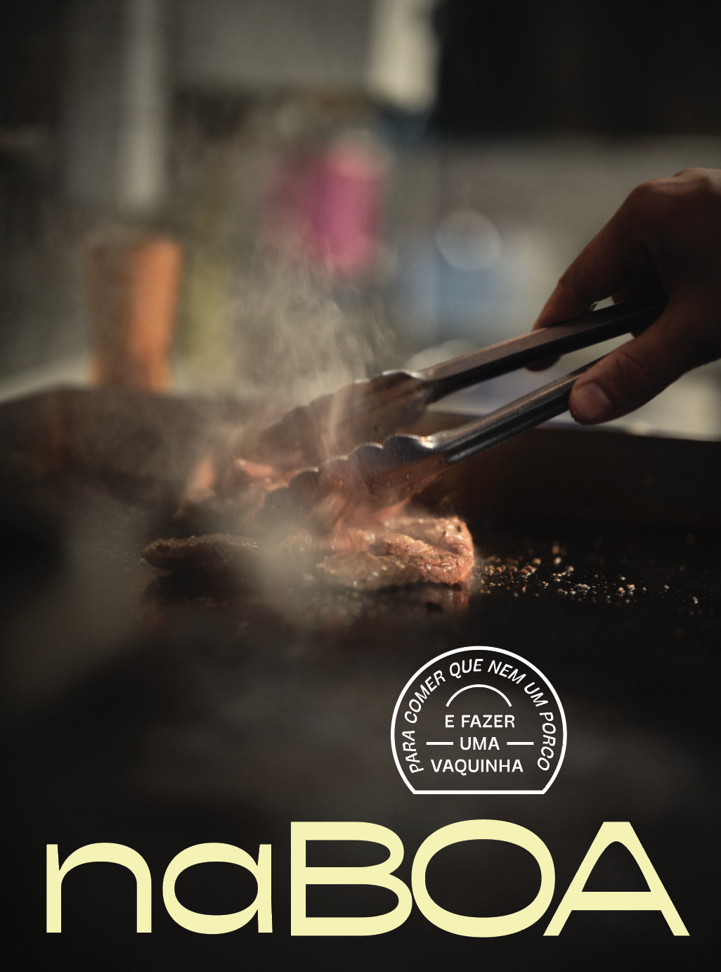 Pessoa pegando carne com uma pinça em uma chapa quente, com fumaça e óleo. Texto em destaque: "Na Boa" e uma frase circular dizendo "Para comer que nem um porco e fazer uma vaquinha".