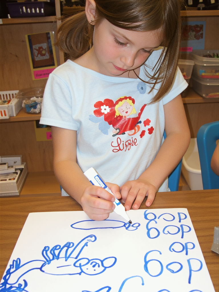 A young girl practices handwriting and writes dog