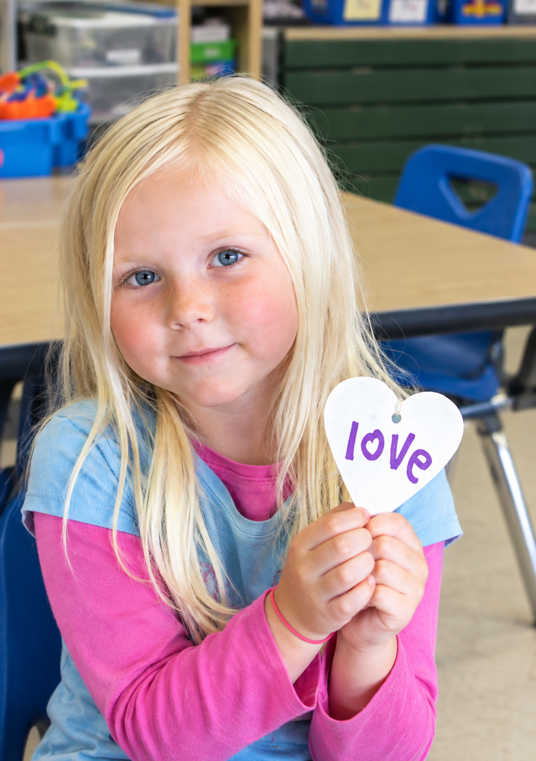 A Blonde child shows her favorite word, love