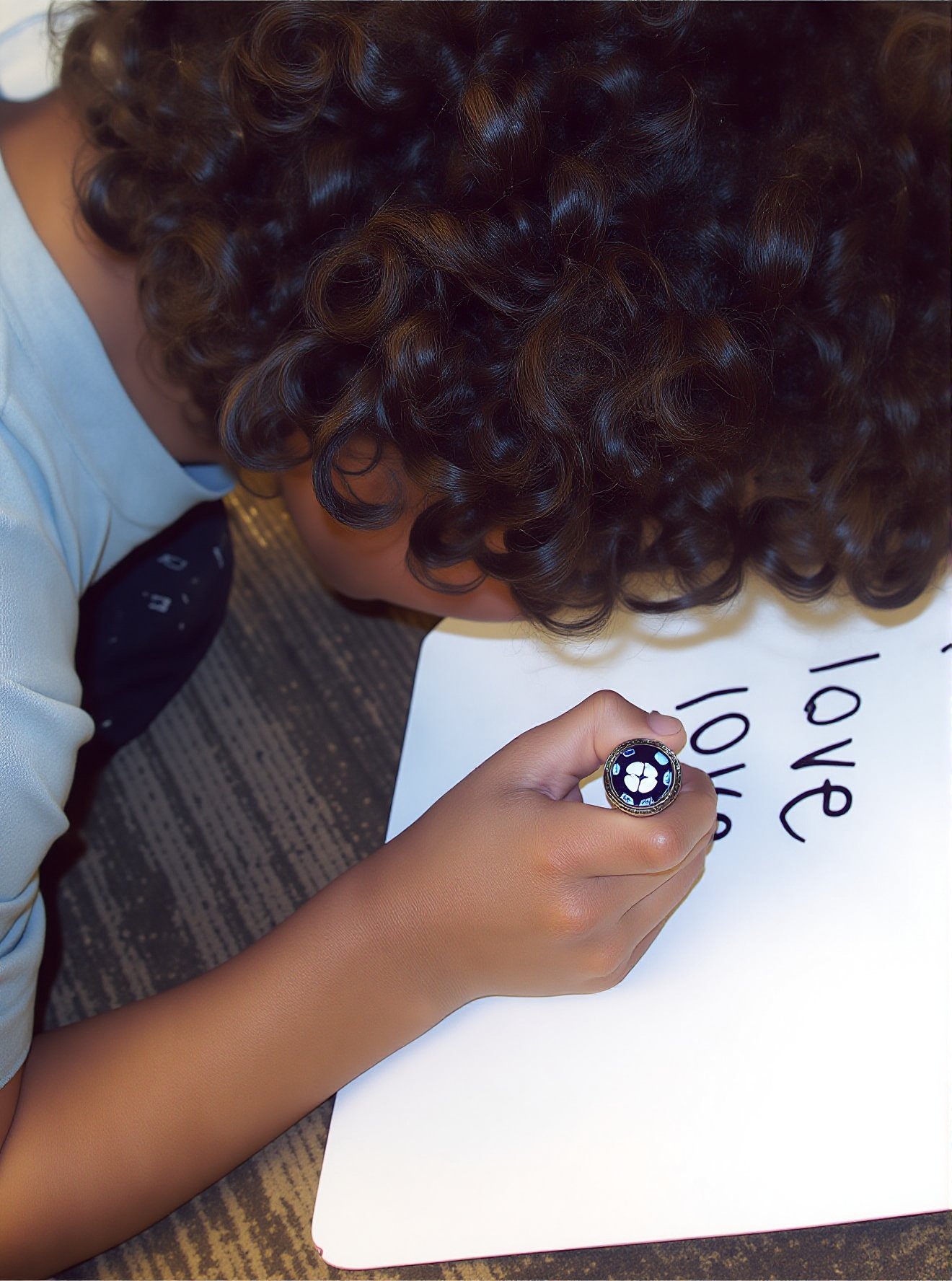 A boy practices handwriting by writing a heart word