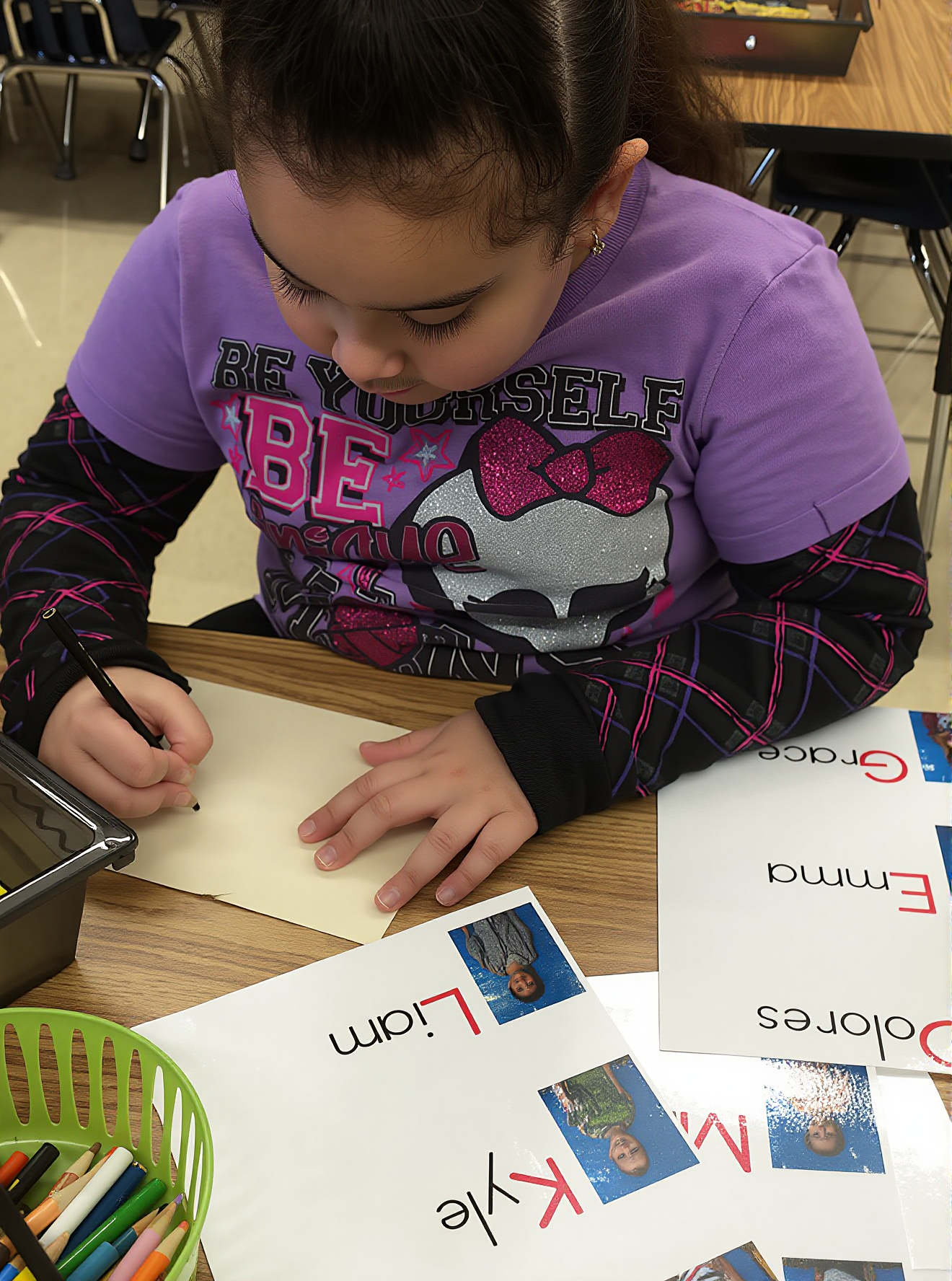 A kindergartner practices handwriting of names