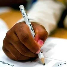 A young boy demonstrates how to hold a pencil