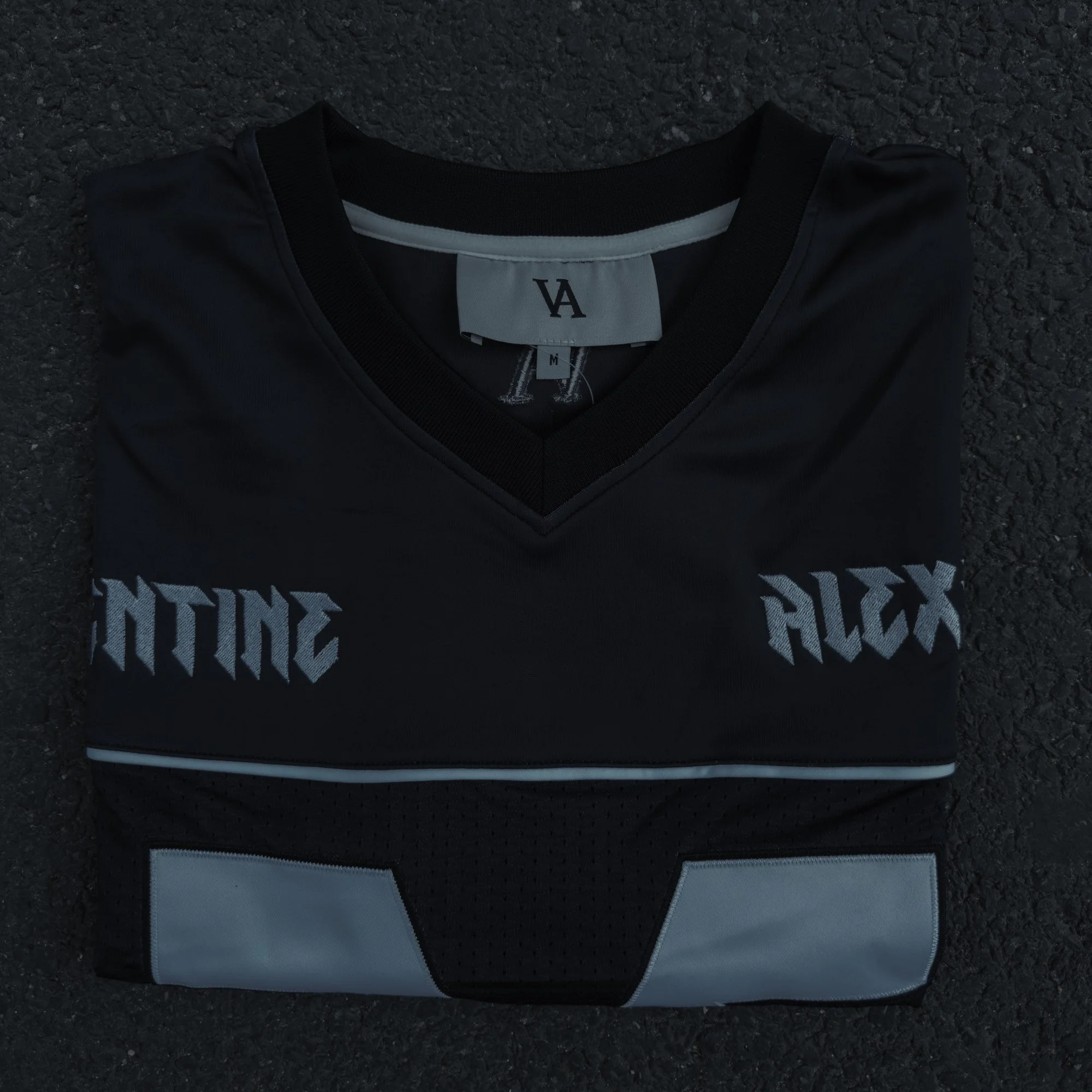 Valentine Alexander 77 Jersey in Off Black, folded on  concrete