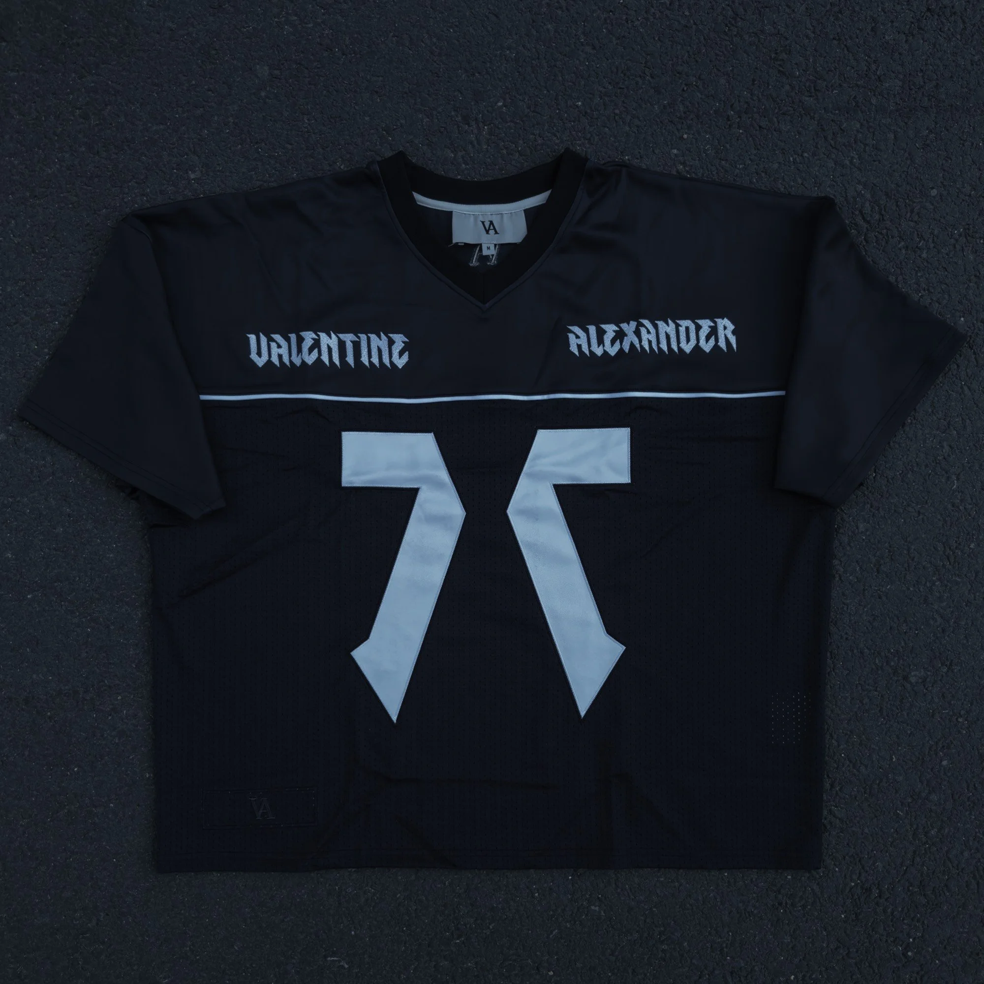 Valentine Alexander 77 Jersey in Off Black, flat lay  front — ribbed V-neck and embroidered monogram