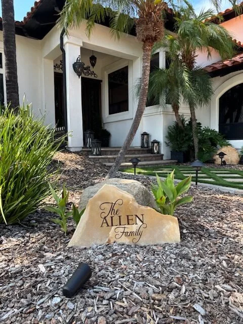 A house with a front porch, palm trees, and a sign that reads "The Allen Family".