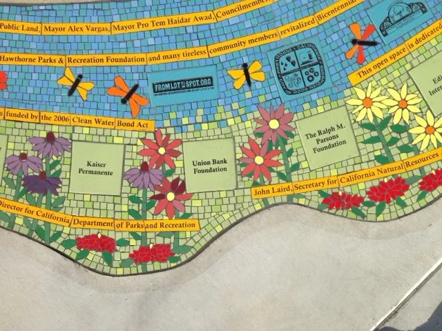 Colorful mosaic map featuring various flowers, bees, and labels of local organizations and foundations, with a prominent open space labeled as a community area.