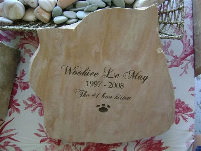 Memorial plaque for Wookiee Le May, a cat, with dates 1997-2008 and the phrase 'The #1 boo kitten,' featuring a paw print.
