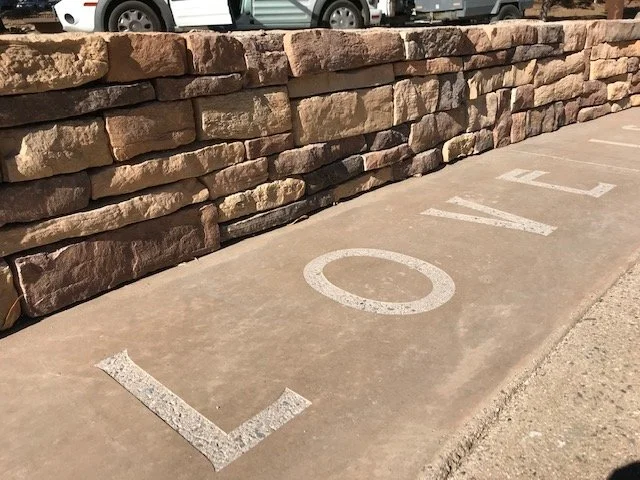 Hockey stick and puck painted on sidewalk indicating a hockey game spot.