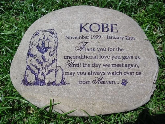Gray memorial stone with a drawing of a dog and engraved text thanking Kobe, who passed away in January 2010, for unconditional love.