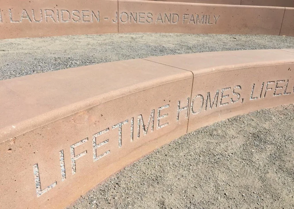 A stone or concrete memorial wall engraved with the words 'LAURIDSEN - JONES AND FAMILY' and an inscription that says 'LIFE : TIME HOMES, LIFEL'.