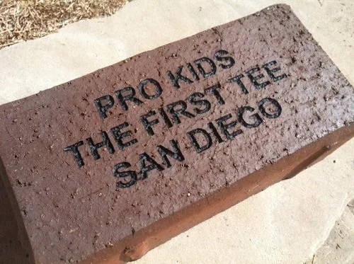 A brick with the text 'Pro Kids The First Tee San Diego' engraved on it.
