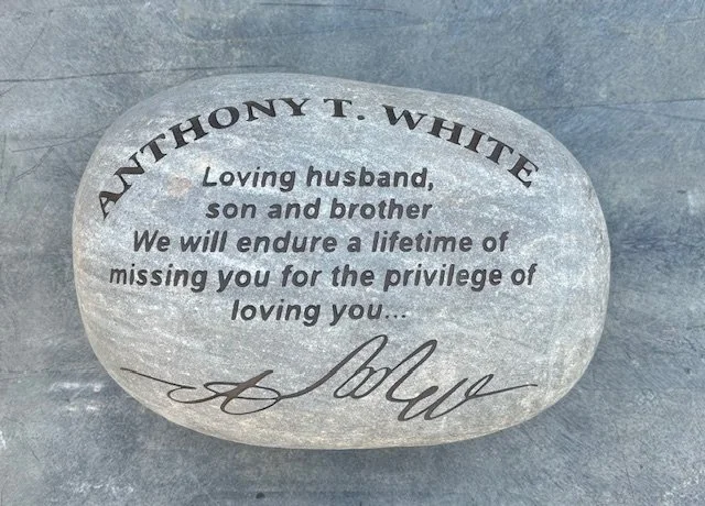 A engraved stone memorial with the name Anthony T. White, dedicated to his wife, son, and brother, expressing love and remembrance.