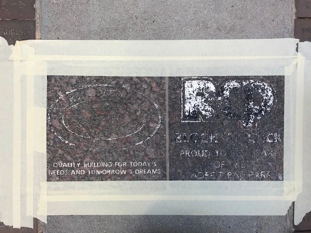 Stencil art on pavement featuring the words "Quality building for today's needs and tomorrow's dreams."