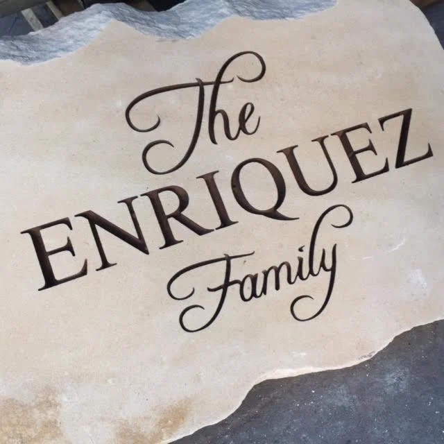 Handwritten sign with the text 'The Enriquez Family' on a beige parchment.