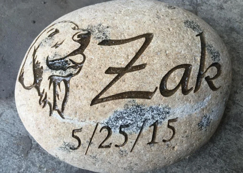 Engraved stone with a dog illustration, the name "Zack," and the date "5/25/15."