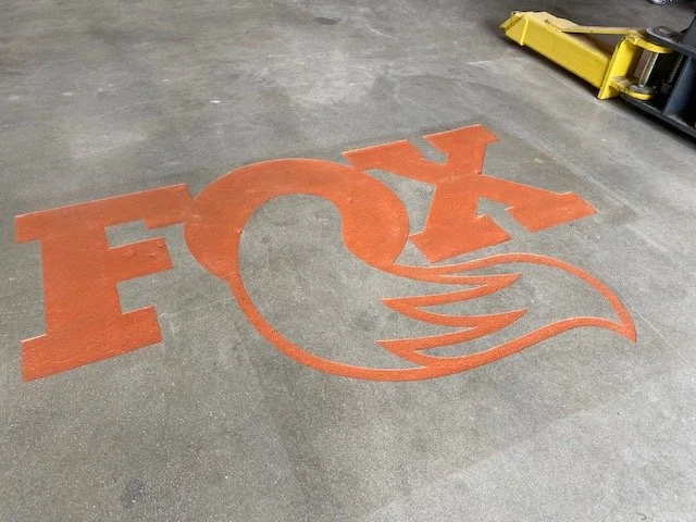 Floor with a large Fox logo painted or printed on it, featuring the word 'FOX' and a stylized fox tail design.