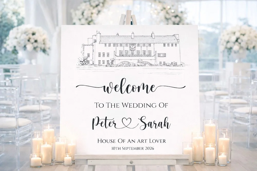 Wedding welcome sign with house drawing, surrounded by candles, in a bright decorated venue.