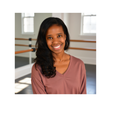 Smiling woman with dark, wavy hair in a dance studio with ballet barres and windows