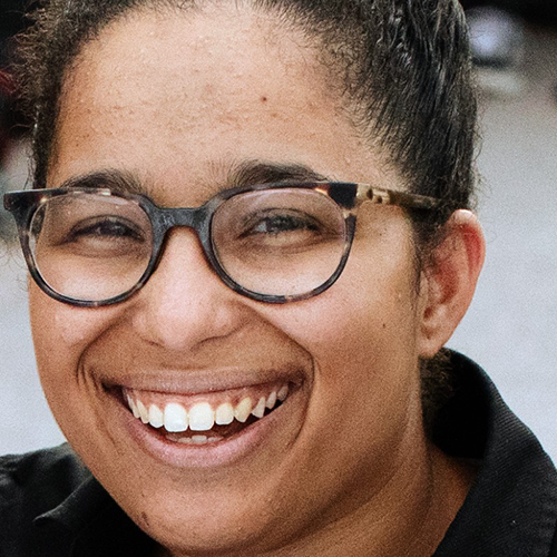 Close-up of a face wearing glasses, a big smile and dark hair