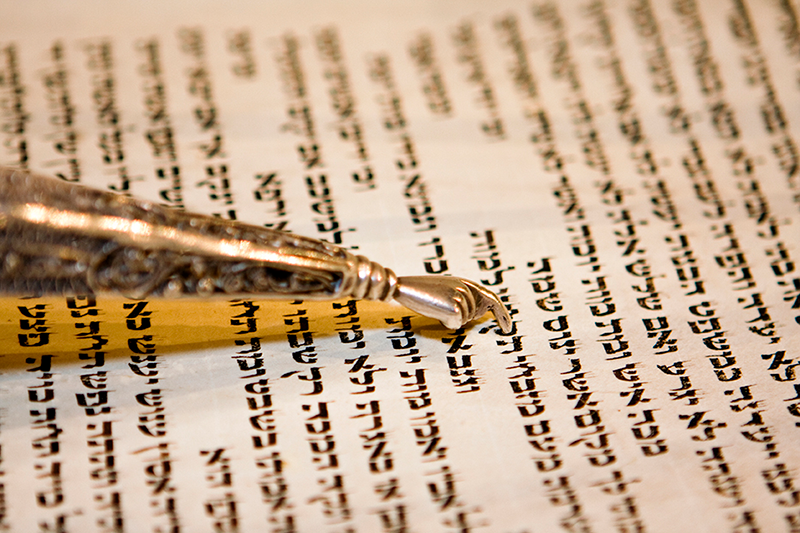 Close-up of a silver letter opener resting on a handwritten letter with black text.