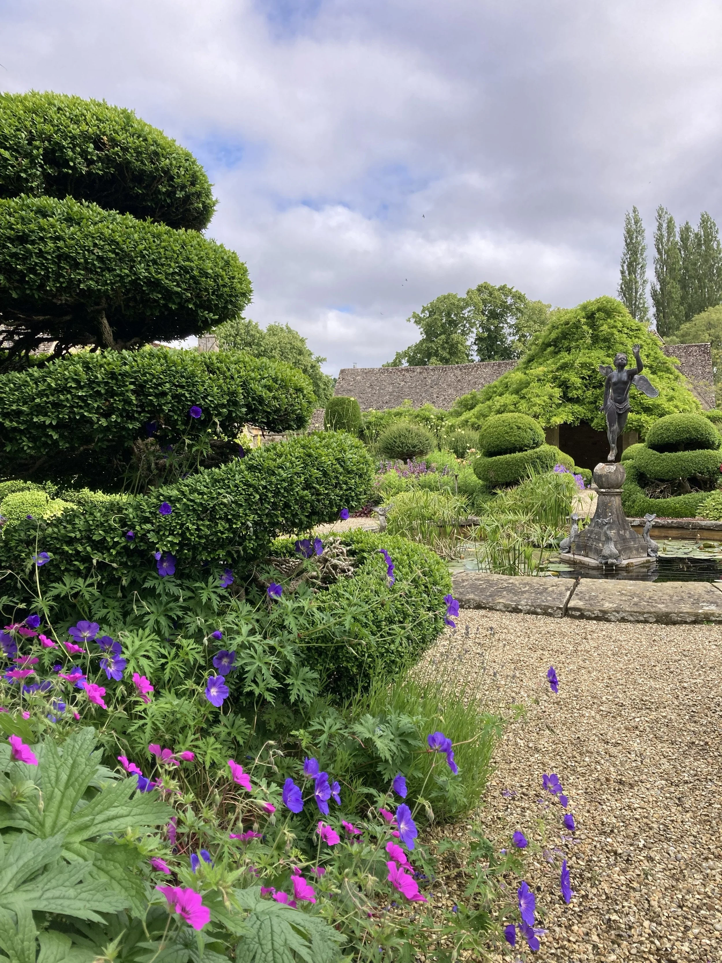 Cotswold gravel garden with box topiary, herbaceous perennials and a pond.