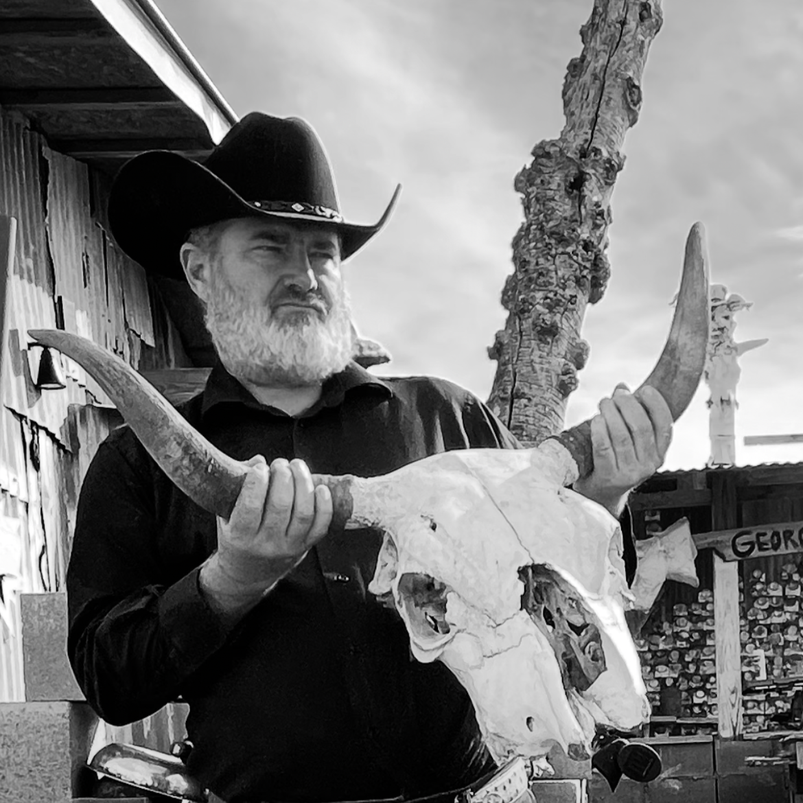 Artist George Zupp in Far West Texas holding a longhorn skull.