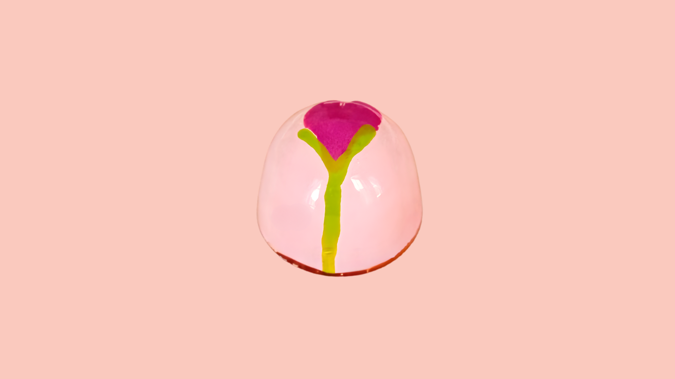Close-up of a pink flower bonbon design against a pink background.