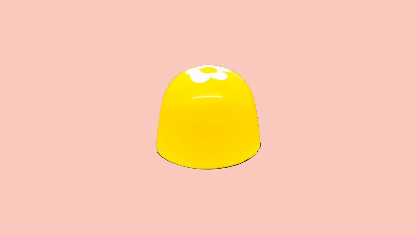 Yellow bonbon with a white flower design.