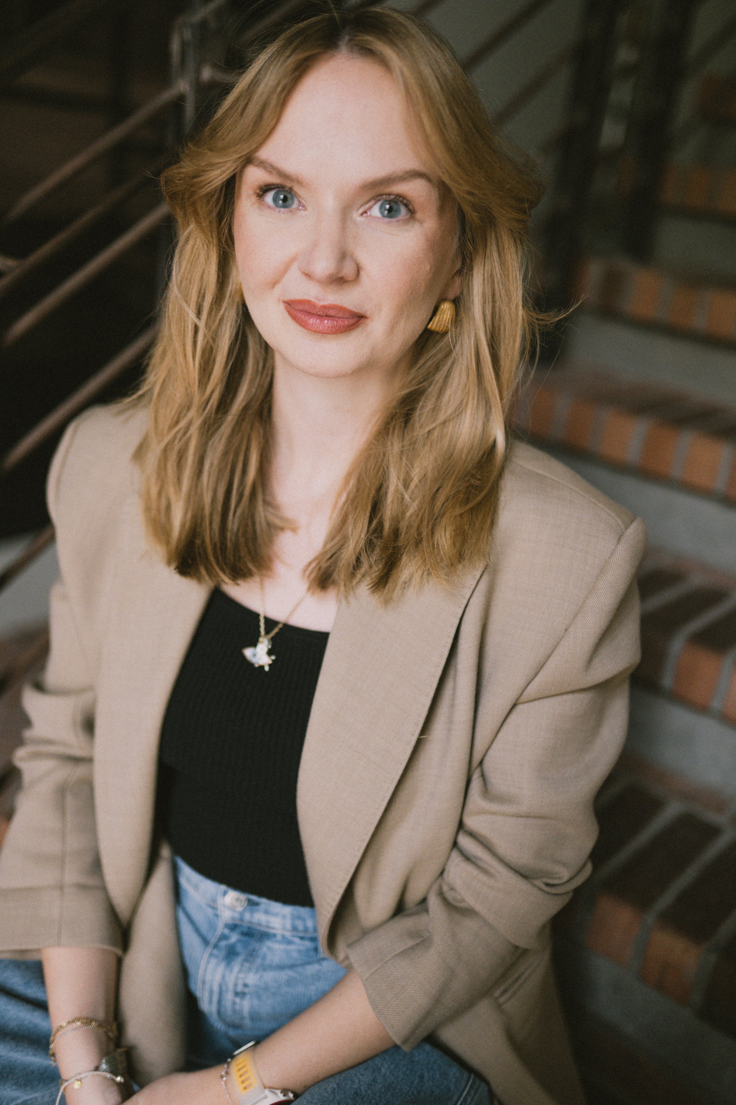 Kristina Lunz lächelnd in beigem Blazer und schwarzem Top