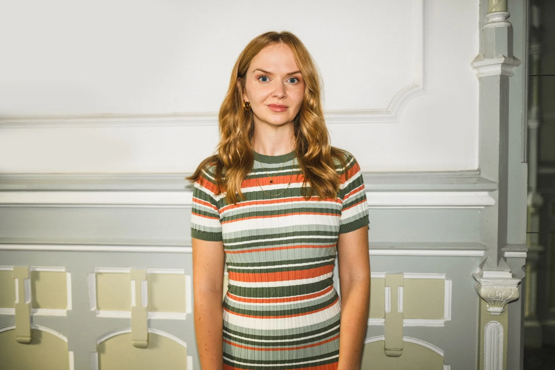 Kristina Lunz in gestreiftem Oberteil, stehend in historischem Gebäude