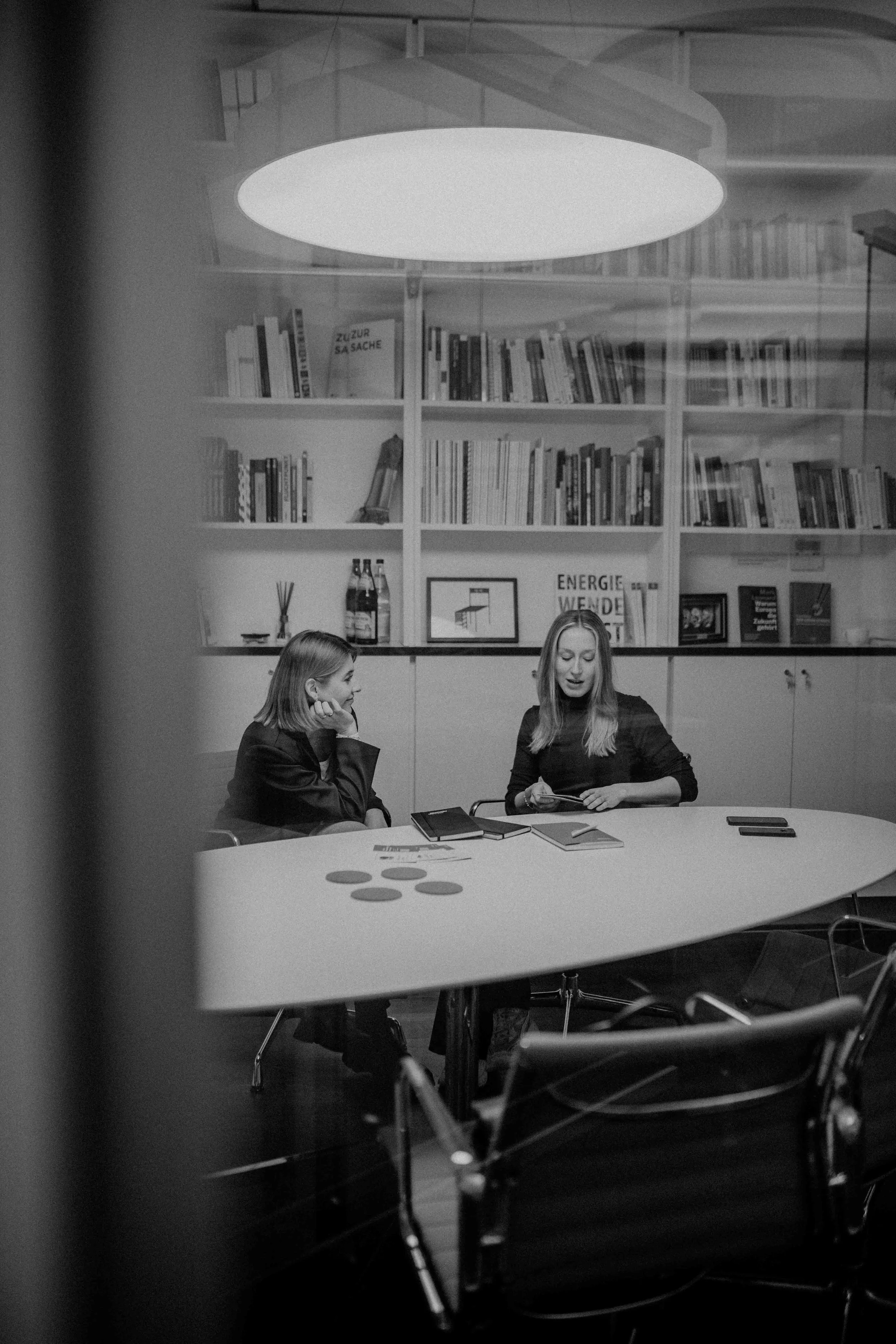 Schwarz-weißes Foto von zwei Personen in einem Besprechungsraum