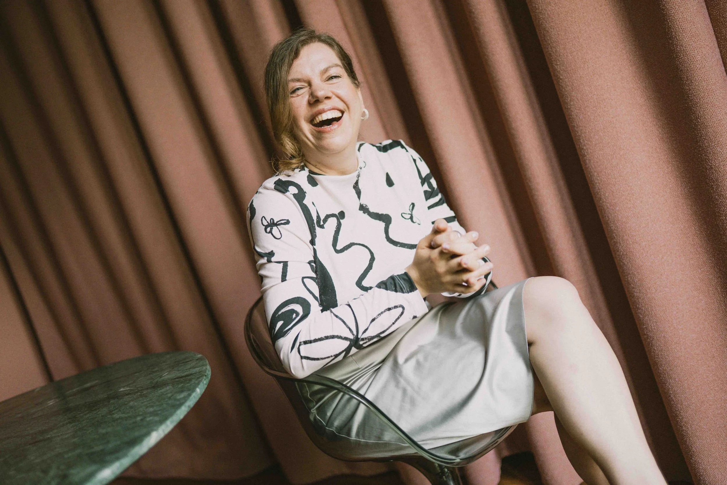 Jeannette Gusko lachend, im gemusterten Oberteil