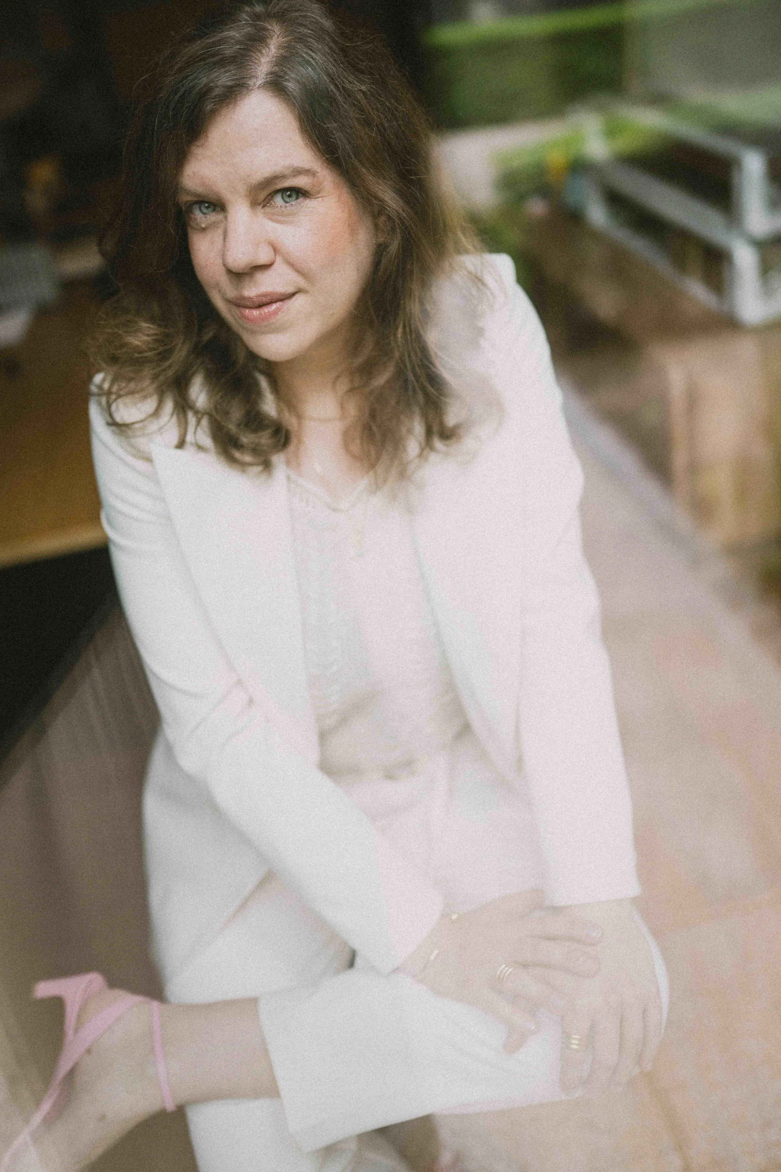 Jeannette Gusko in weißem Spitzen-Outfit, lächelnd