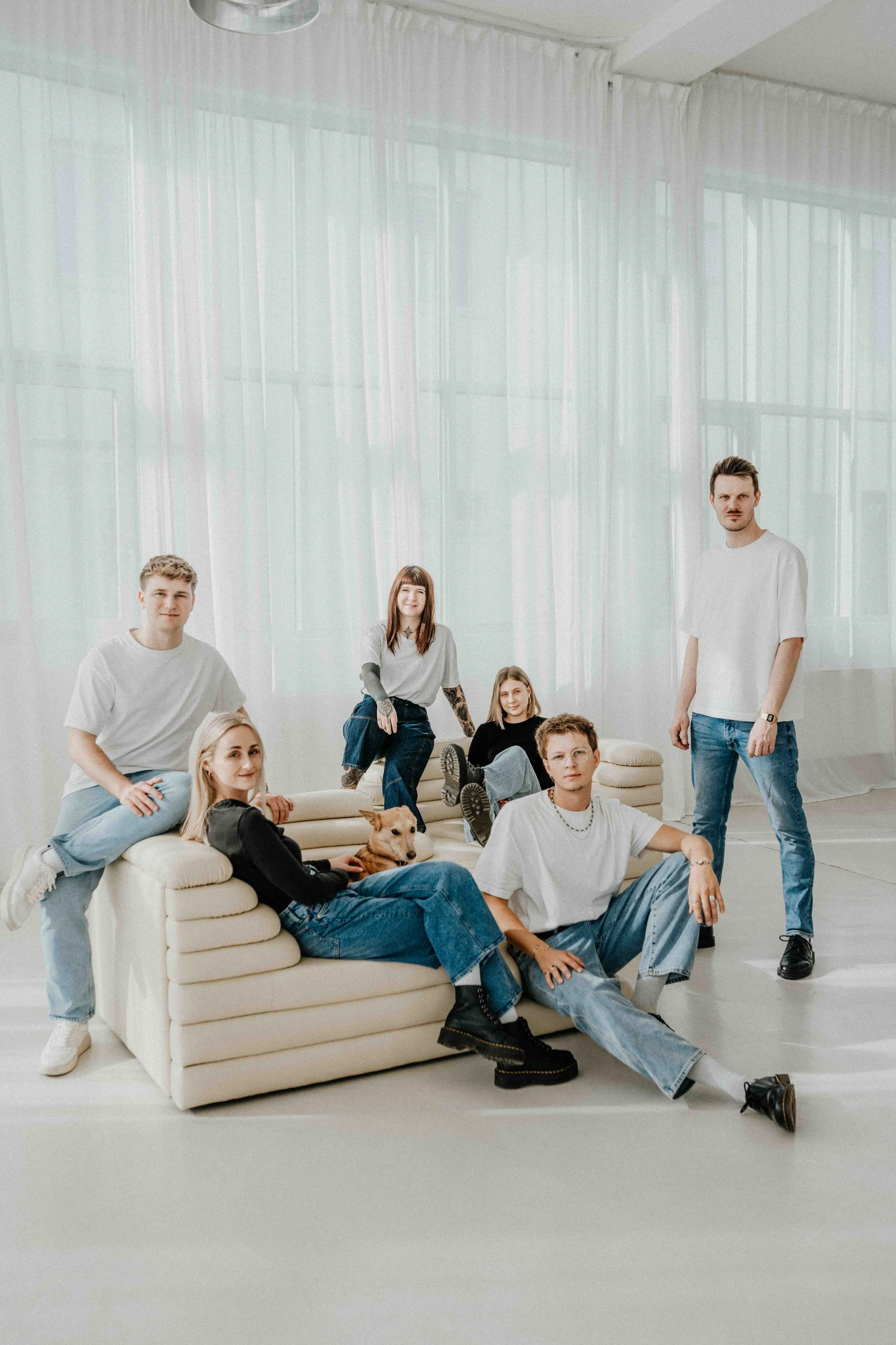 Gruppenfoto eines Teams entspannt auf einem Sofa sitzend