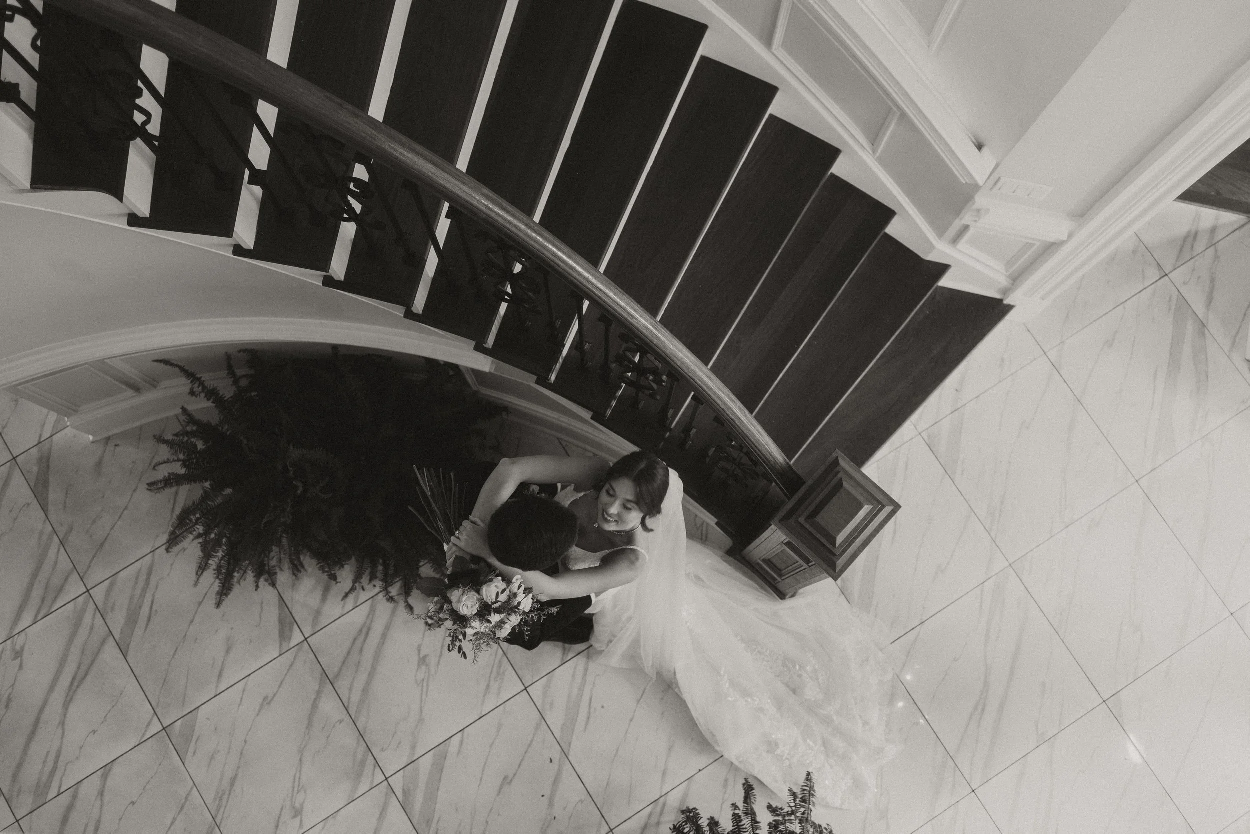 Bride and Groom dancing at the bottom of a staircase at their wedding