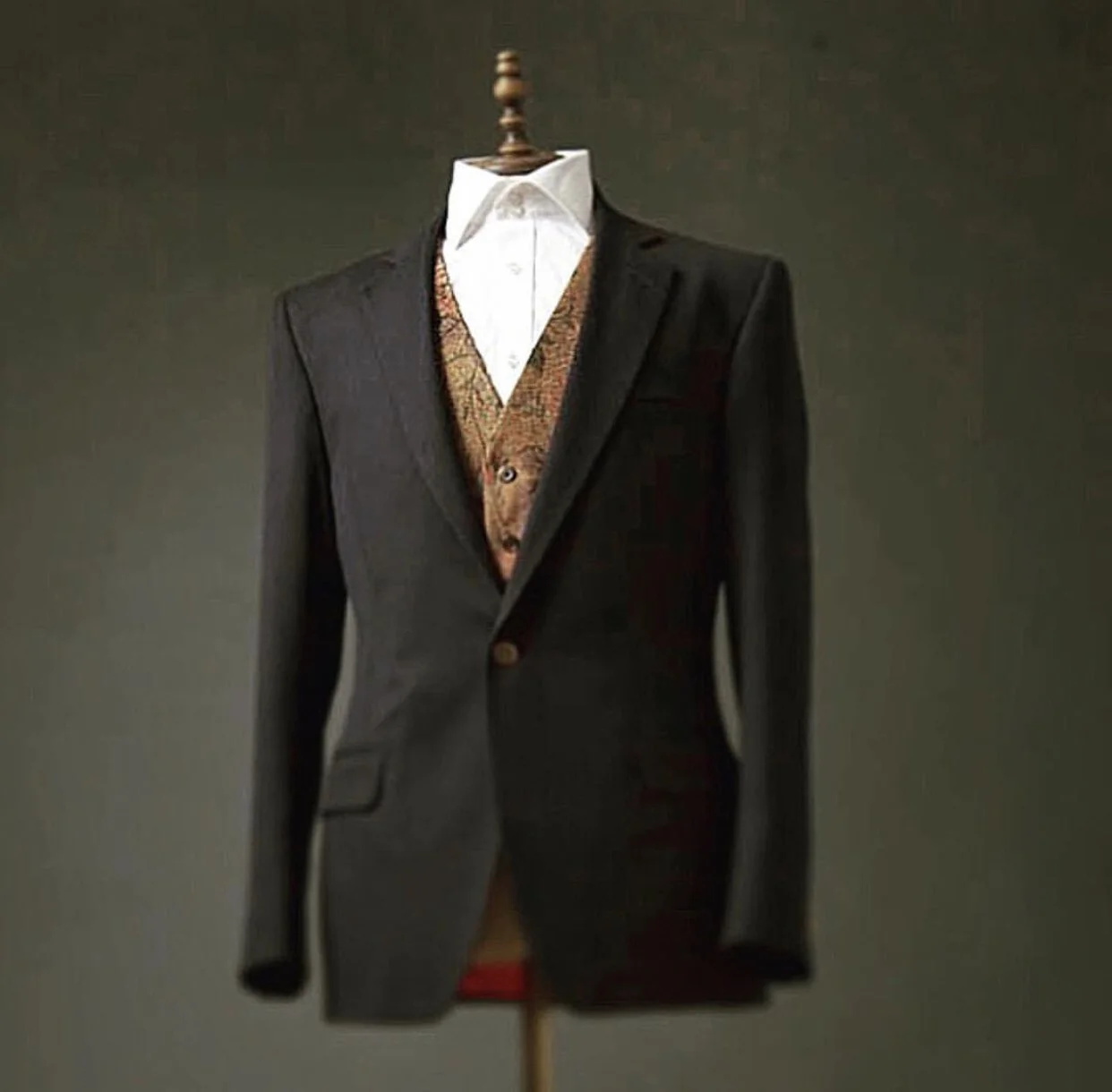 Dark suit jacket, white dress shirt, patterned vest displayed on a mannequin