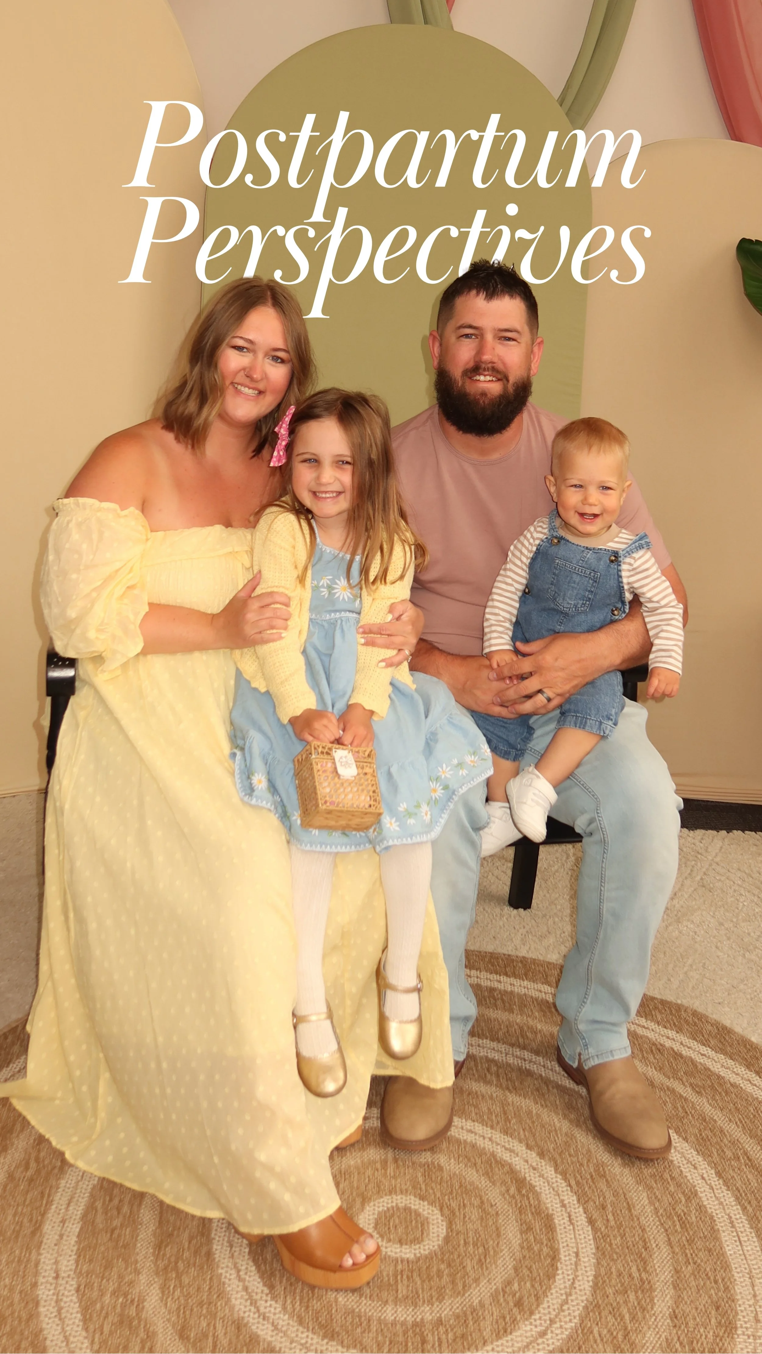 A mom and dad sitting. The mom is wearing a flowing dress holding her child daughter. The father is holding a young son.
